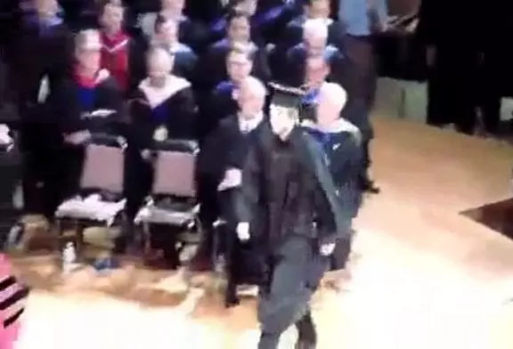 Lors d’une remise de diplome , un jeune homme trébuche devant les marches .