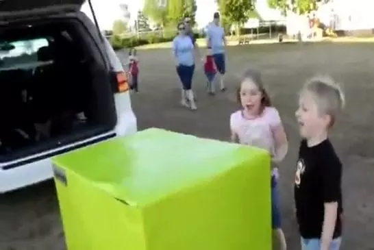 Deux enfants déballent un cadeau contenant leur père militaire