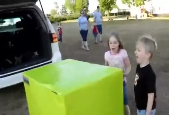 Deux enfants déballent un cadeau contenant leur père militaire