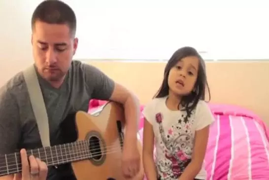 Père et fille interprètent une chanson à la guitare