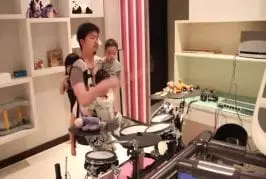 Incroyable papa batteur joue avec ses 3 enfants dans les bras