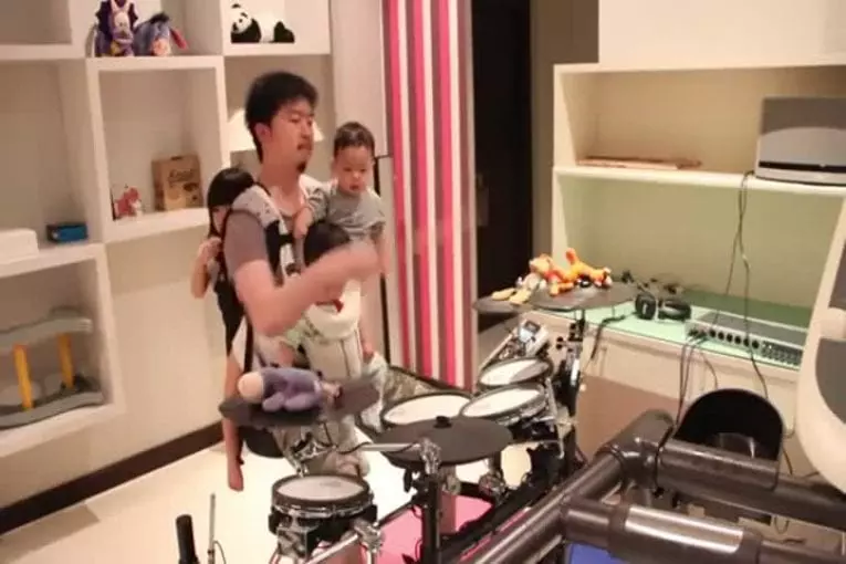 Incroyable papa batteur joue avec ses 3 enfants dans les bras