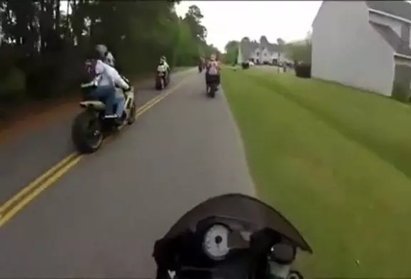 Fille tombe de moto et se coince sur le pneu