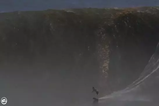 Mec monte une énorme vague sur un skimboard