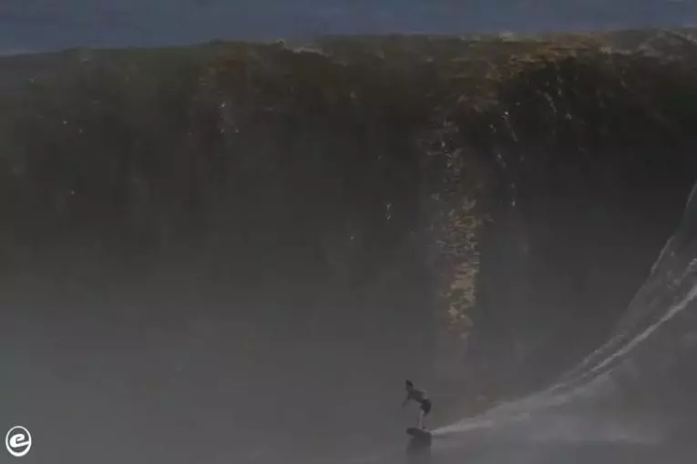 Mec monte une énorme vague sur un skimboard