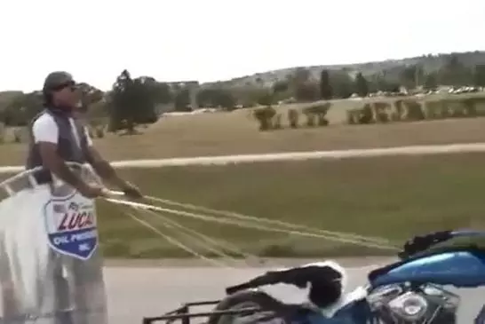 Gars fait un char à l’aide d’une moto