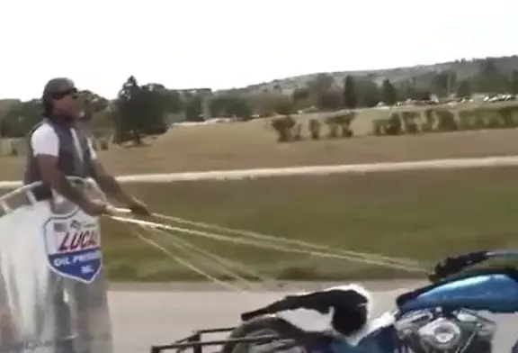 Gars fait un char à l’aide d’une moto