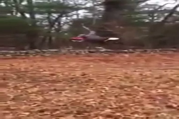 Mec attache une corde à sa motocross et vole autour d'un arbre