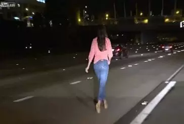 Fille bourrée marche sur l’autoroute