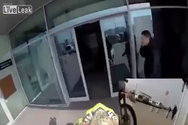 Gars sur la moto roule à travers le centre commercial