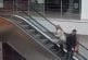 Une blonde dans les escalators d'un centre commercial