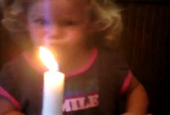 Petite fille soufflant une bougie