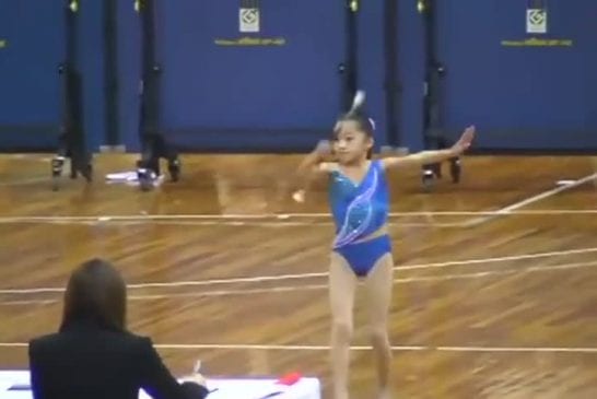 Une petite asiatique fait du baton twirling