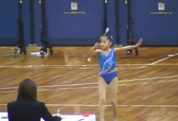 Une petite asiatique fait du baton twirling