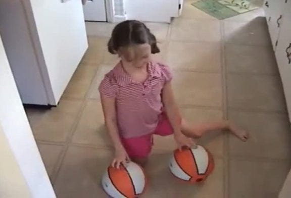 Fille de 8 ans jongle avec des ballons de basket