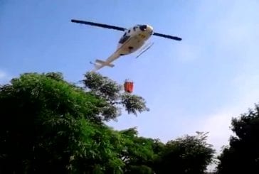 Hélicoptère remplit une poche d’eau dans une piscine publique
