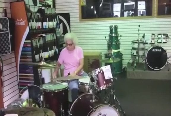 Grand-mère joue du rock dans un magasin de musique