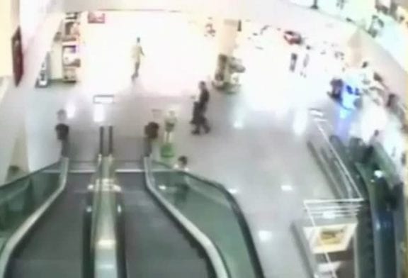 Jeu dangereux d’un homme avec son fils sur un escalator
