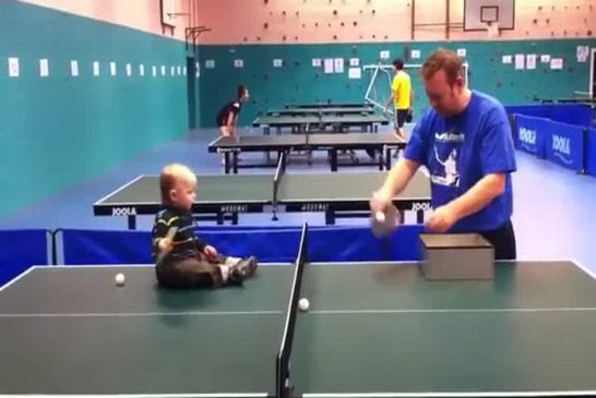 Un bébé joue au ping pong