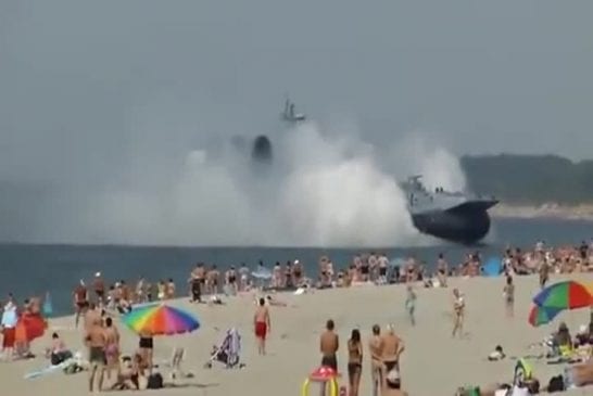 Aéroglisseur militaire traverse une plage bondée