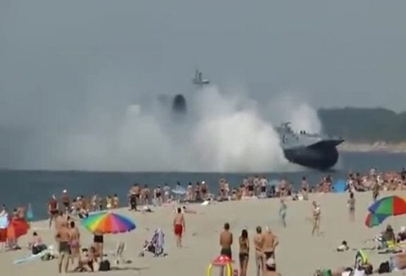 Aéroglisseur militaire traverse une plage bondée