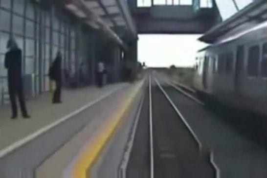 Un homme traverse les voies devant un train