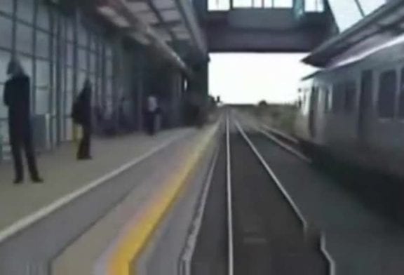 Un homme traverse les voies devant un train