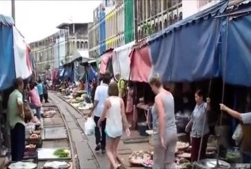 Train indien traverse un marché très fréquenté