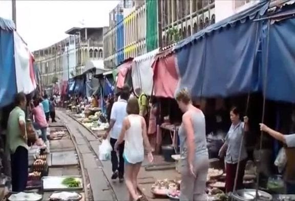 Train indien traverse un marché très fréquenté