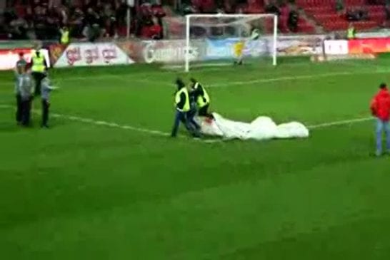 Un supporter arrive en parachute à un match de football