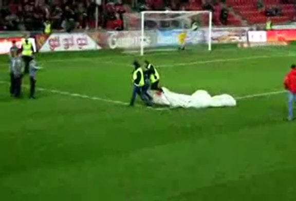 Un supporter arrive en parachute à un match de football