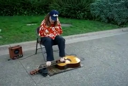 Homme joue de la guitare avec les orteilles