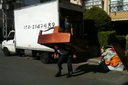 Homme russe joue du piano avec un second piano sur son dos