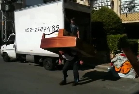 Homme russe joue du piano avec un second piano sur son dos