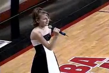 Basketteur aide une jeune fille à chanter l’hymne national